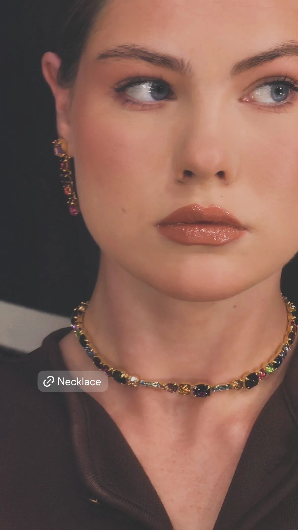 Model wearing a multicoloured crystal necklace and drop earrings