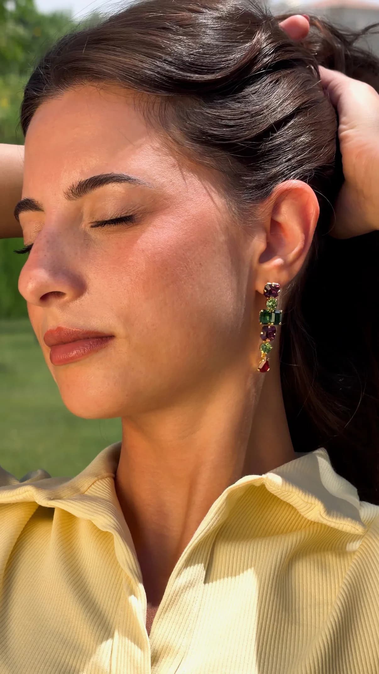 Model with eyes closed wearing a crystal drop earring